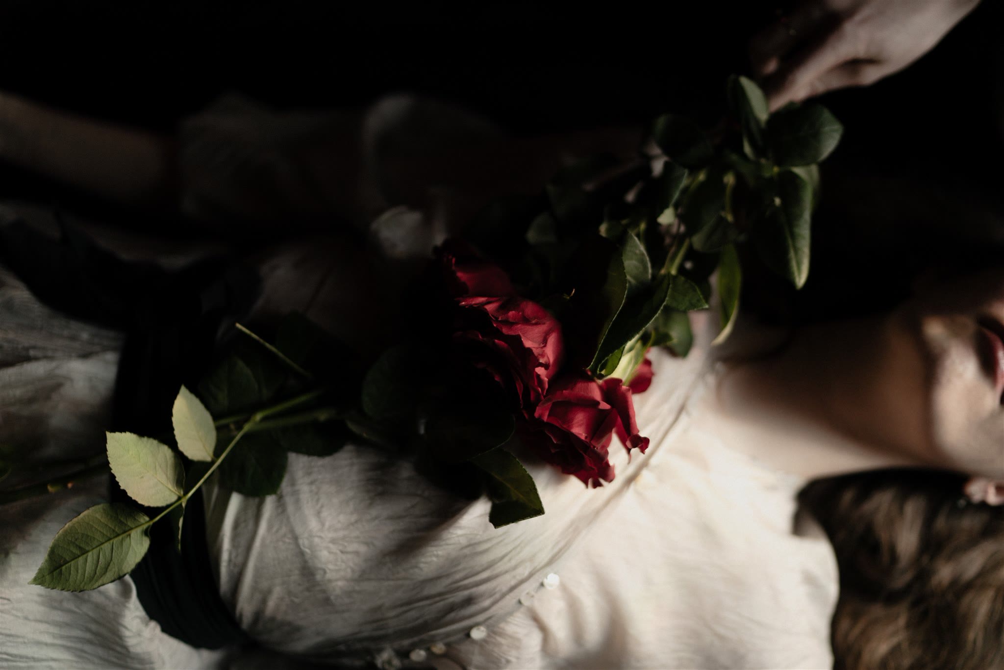 Rote Rosen auf einem weißen Kleid